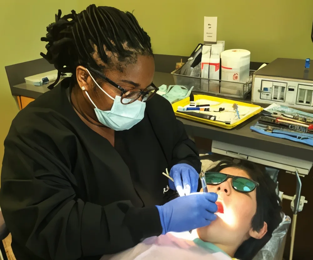A dental assistant gently caring for a young patient at Children's Dentistry, Atlanta